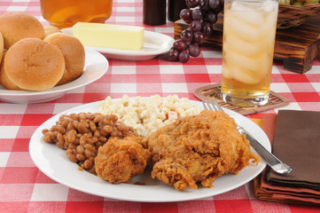 Fried chicken and baked beans on a picnic table