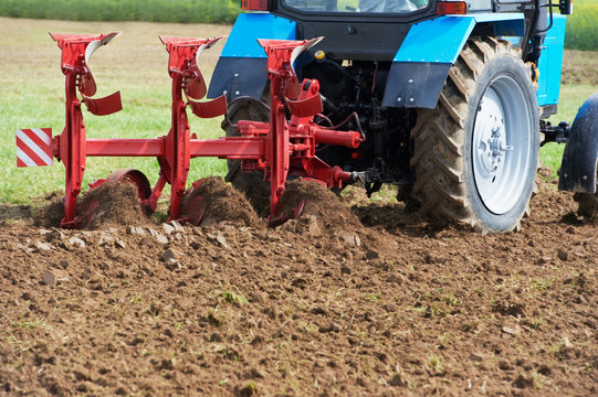 Ploughing tractor at field cultivation work