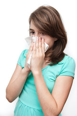 Sick teen girl using tissue. All on white background.