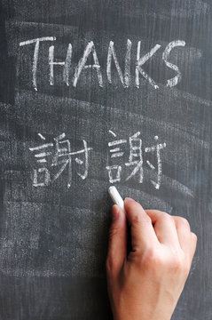 Thanks - word written on a blackboard with a Chinese version