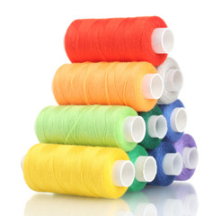 Pyramid of many-coloured bobbins of thread isolated on white