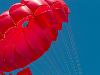 Red parachute against the blue sky
