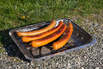 Sausages on one time use grill