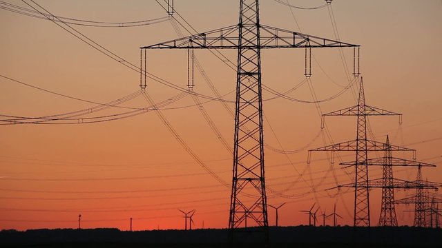 Sonnenuntergang Wind Turbinen mit &Uuml;berlandleitungen