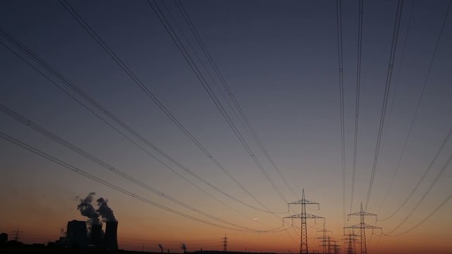 Power plant with power lines during sunset