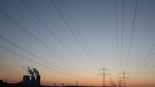 Zeitraffer Kraftwerk mit Stromleitungen im Sonnenuntergang