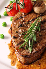 close-up of juicy beef steak covered with pepper  and salt