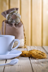 blue coffee cup with cookies and bag