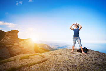 young tourist looks for way from the rocks top