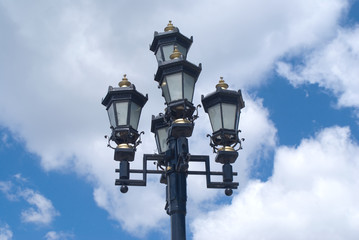 Fototapeta na wymiar Retro styled lighting lantern over cloudy sky
