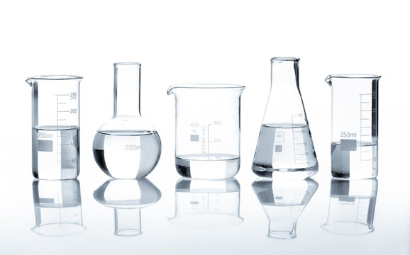 Five laboratory flasks with a clear liquid, isolated