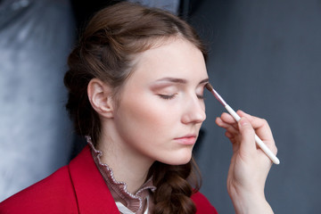 Obraz premium pretty young woman having powder applied by a make-up artist