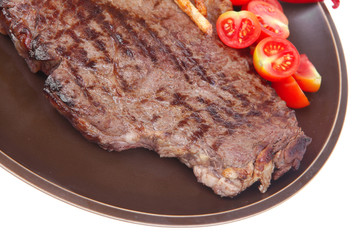 beef steak on dark plate with red hot chili pepper
