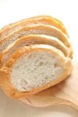 Sliced french bread on wooden cutting board