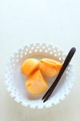 Cut fruit, persimmon on white background with copy space