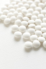 Fototapeta na wymiar close up of white pills on white background with copy space