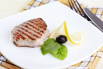 Grilled steak on white plate closeup