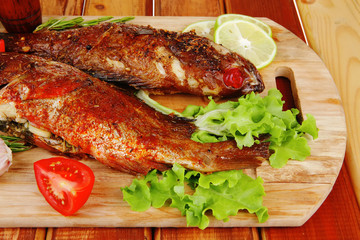 savory on wooden table: two fried fish