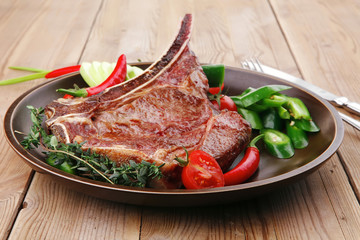 savory : grilled spare rib on dark dish with pepper and tomato
