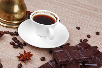 black Turkish coffee in small white mug with coffee beans