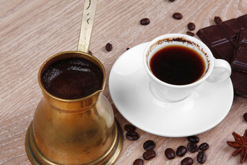 black coffee in small white cup with beans