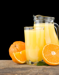 Obraz na płótnie Canvas orange juice in glass and slices isolated on black