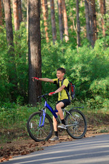 Fototapeta na wymiar A teenager on a bicycle traveling in the woods
