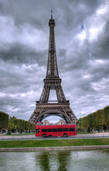 Fototapeta na wymiar ciemne sceny z wieży Eiffla w Paryżu, we Francji i czerwony autobus