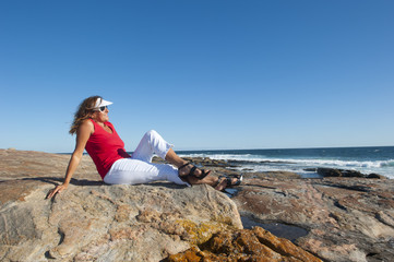 Joyful sexy woman relaxed looking over ocean