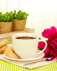 cup hot chocolate, cookies  and flower on table in cafe