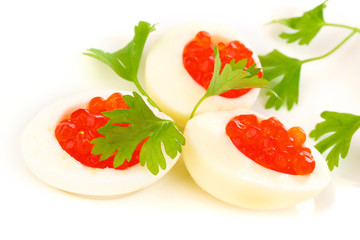 Red caviar in eggs on white plate close-up
