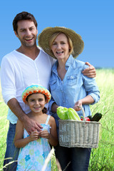 parents and their daughter in a wheat field