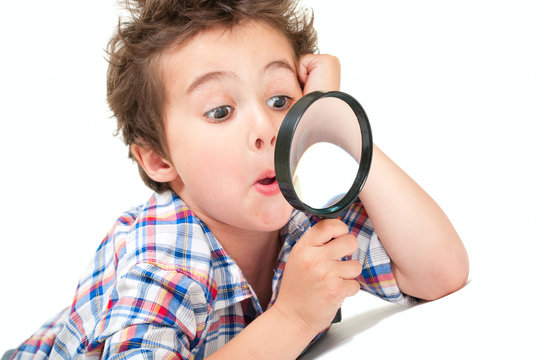 Surprised little boy with weird hair and magnifier