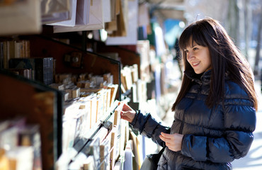 Fototapeta na wymiar Piękna kobieta w Paryżu wybierając książki w odkrytym booksell