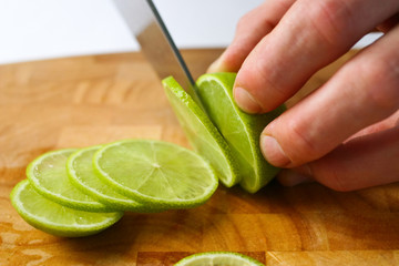Cutting limes on a wooden chopping board