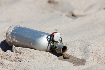 Feldflasche liegt offen auf dem heißen Sand