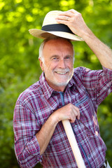 Senior gardener greets with hat