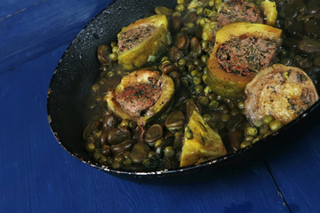 zucchini filled meat with peas over blue