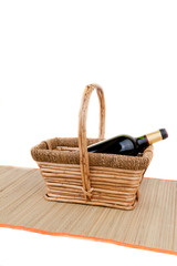 picnic basket with bottle of red dry wine isolated on white