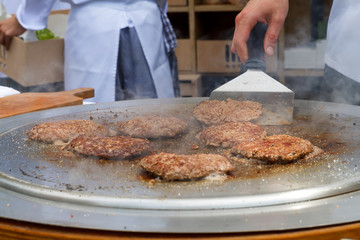 Burgers being grilled on metalic grill plate
