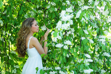 A young Caucasian woman in a beautiful green garden