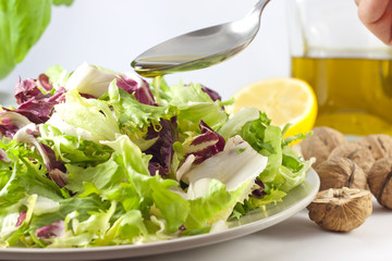 pouring oil and vegetables salad