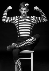 Morose circus performer sitting in a striped dress - 42317095