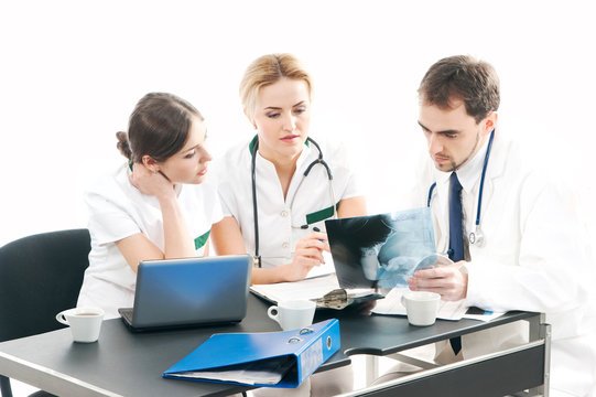A team of three young Caucasian doctors in white clothes