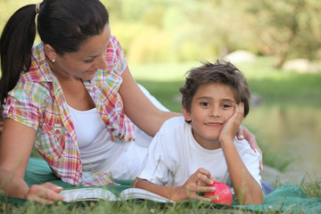 Mother and son lying on the grass