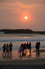 People taking a sunset stroll on Kovalam beach, Kerala, India