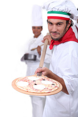 Pizza maker displaying his pizza