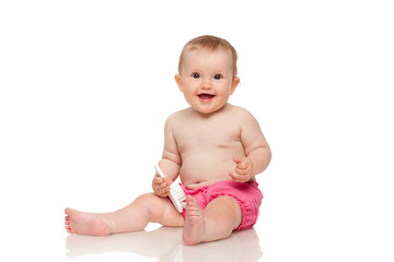 Smiling baby sitting on the floor with the comb over white