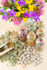 different healing herbs in glass bottles, flowers bouqet in mort