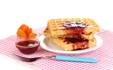Tasty waffles with jam on plate isolated on white